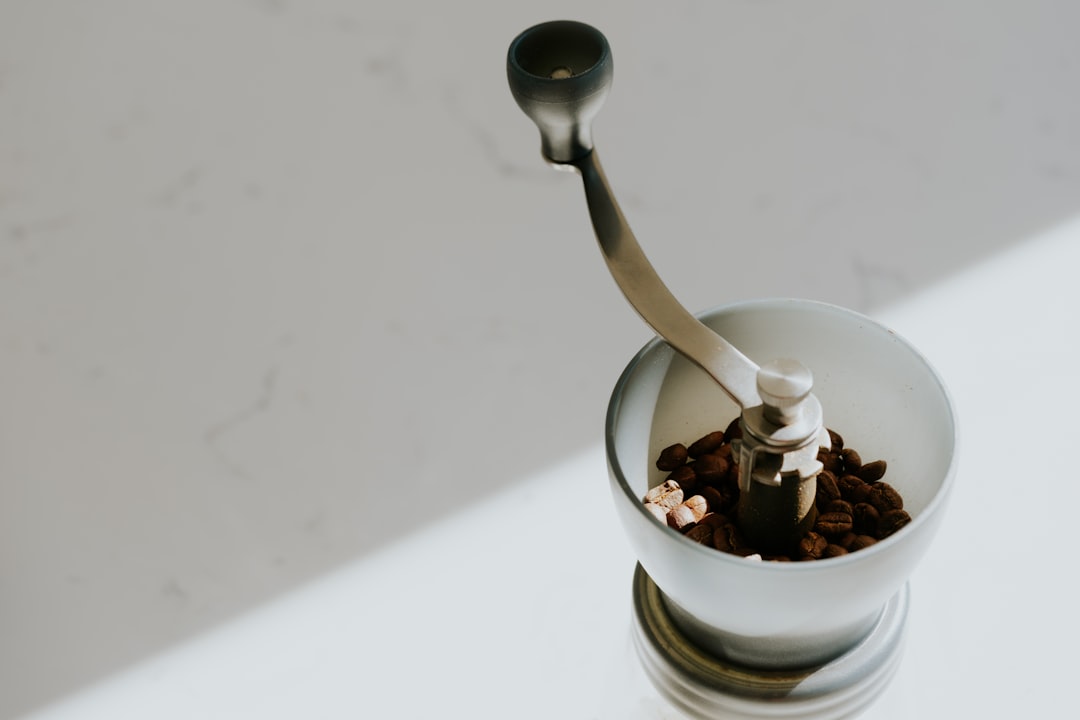 a-spoon-in-a-cup-filled-with-cereal-and-nuts-jfenckevh8q